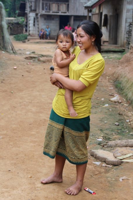 Femme avec enfant dans le village au bord de la rivière au Laos