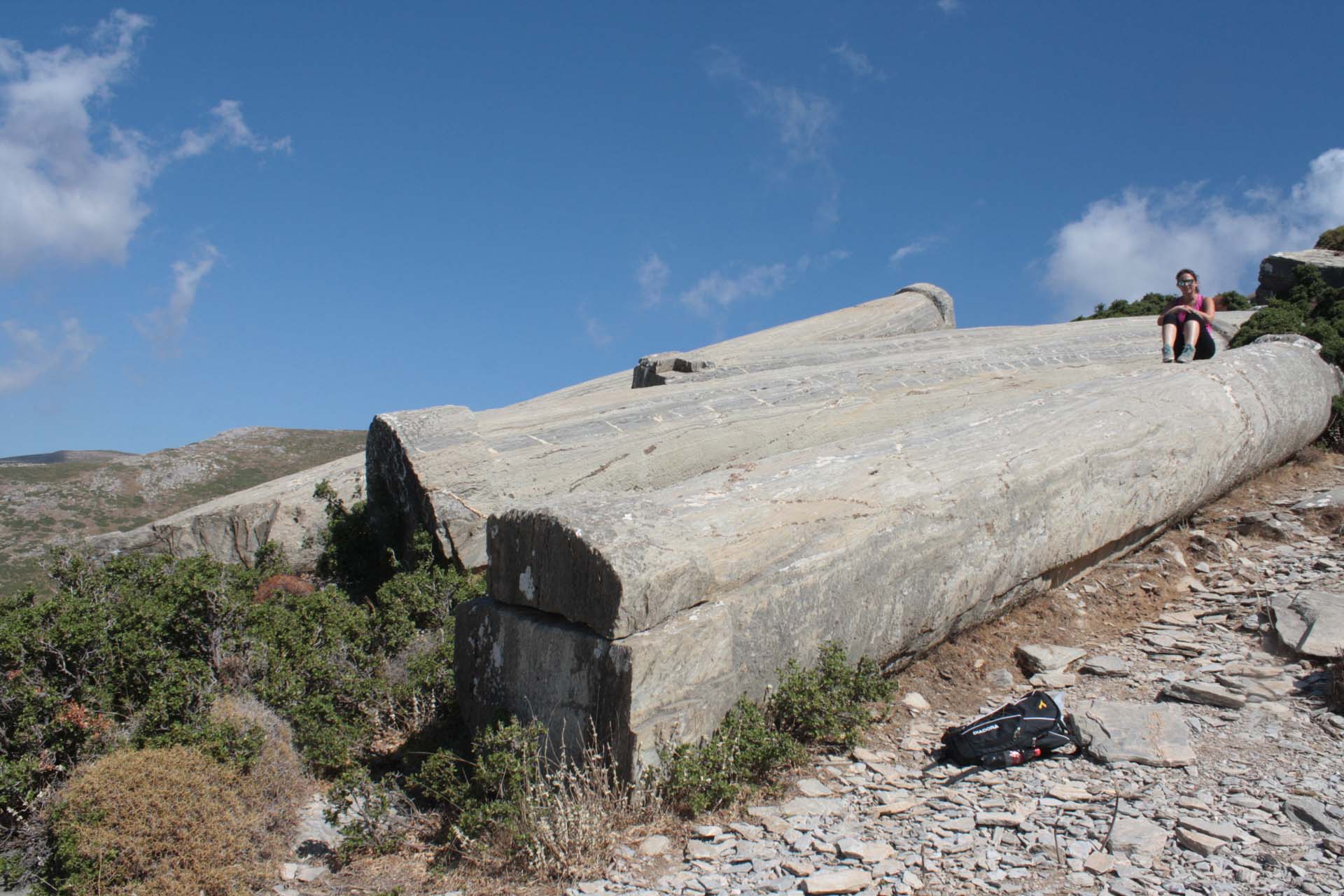 Woman sitting on columns carved in the quarry in Karystos on the Euboea island