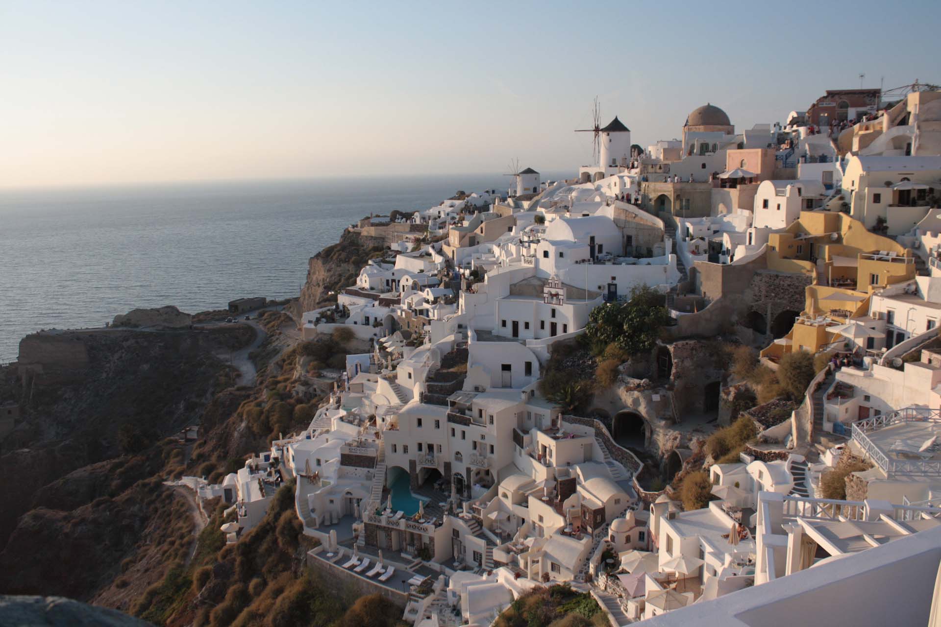 Sunset reflecting on the city of Oia in Santorini white houses mills