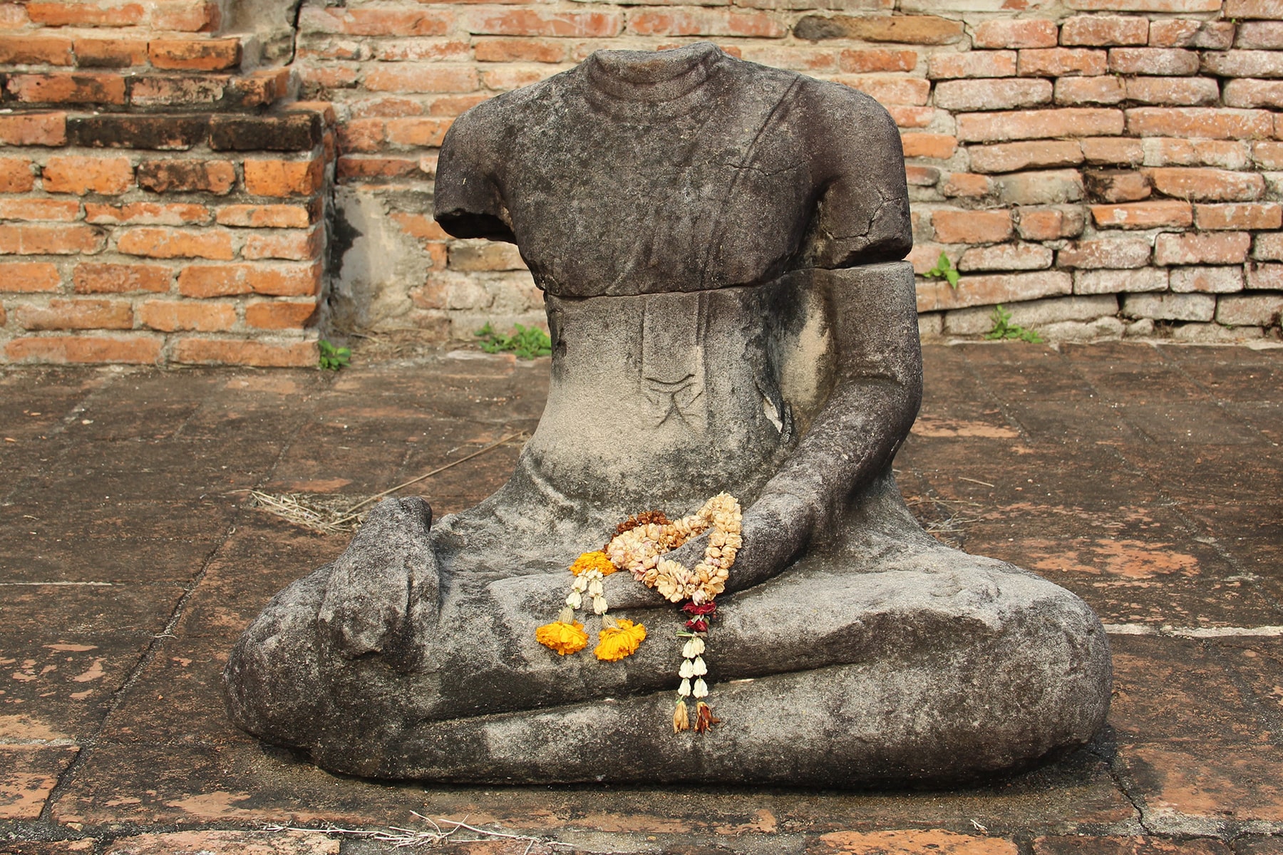 Flower offerings on a statue in the Wat Mahathat in Ayutthaya