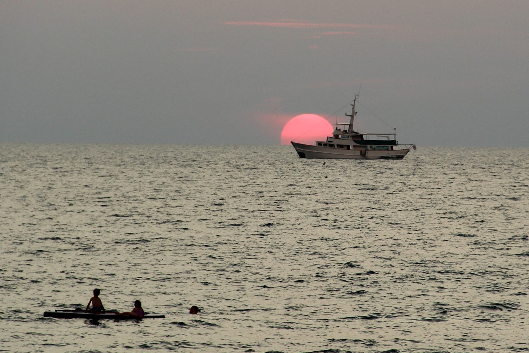 Coucher de soleil Koh Lanta ; soleil rouge qui se couche derrière un bateau