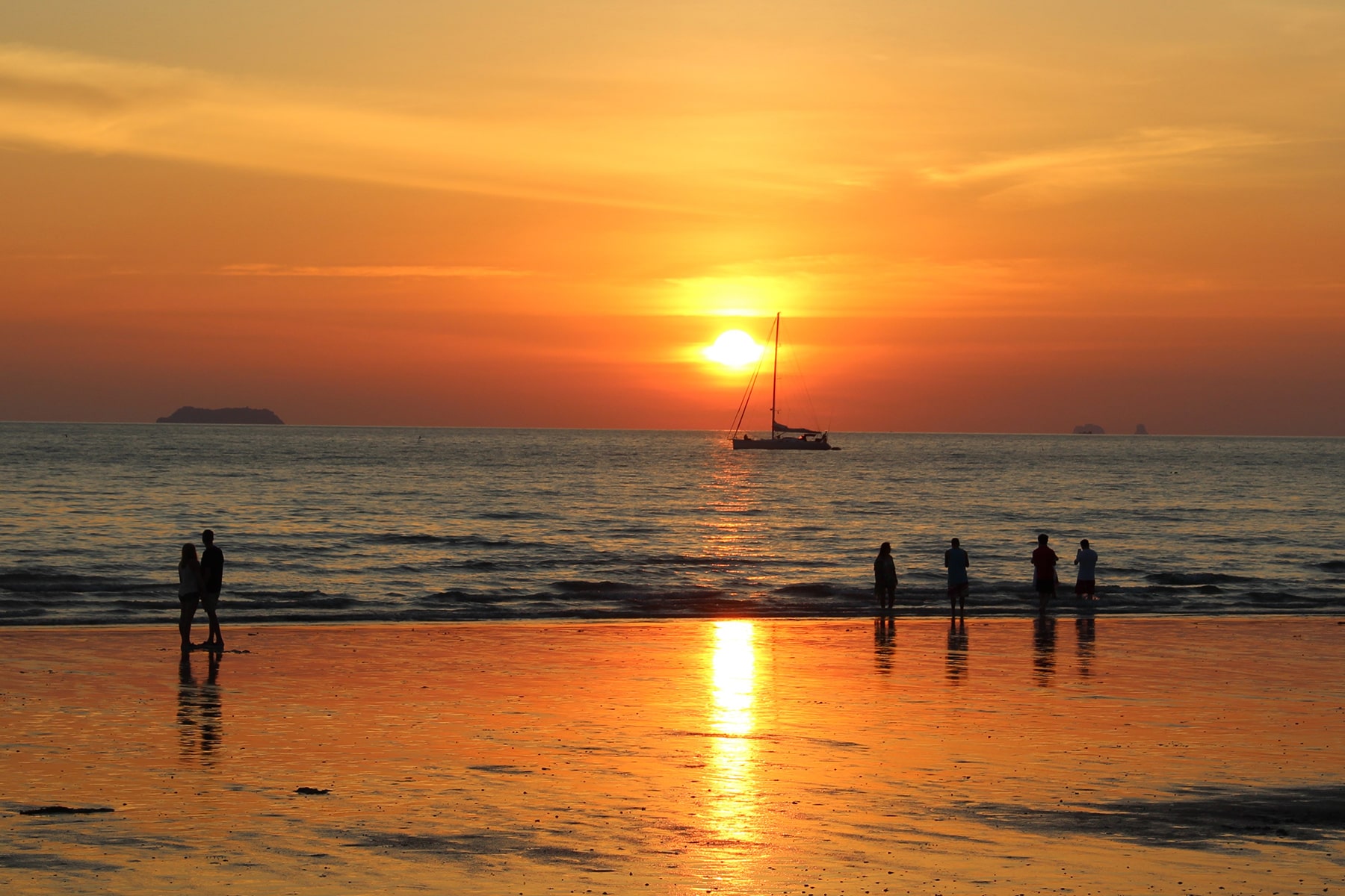 Coucher de soleil orange qui se réflète sur une plage à Koh Lanta